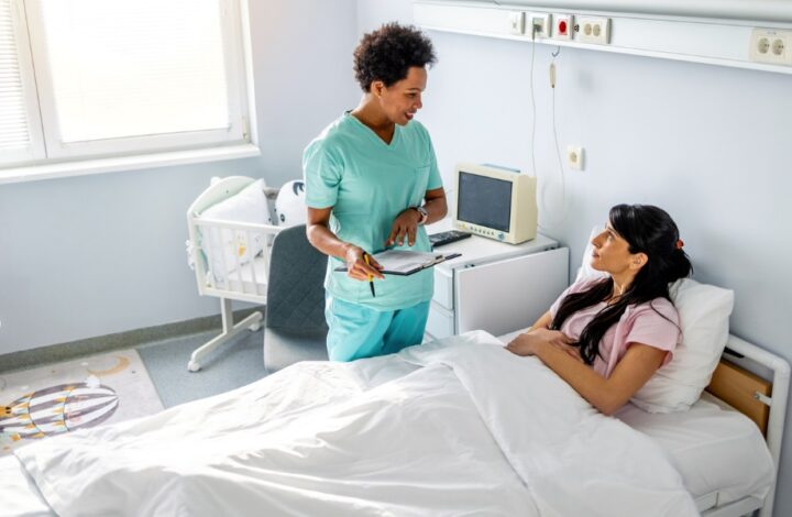 A nurse standing next to a patient in a hospital bed Description automatically generated with low confidence